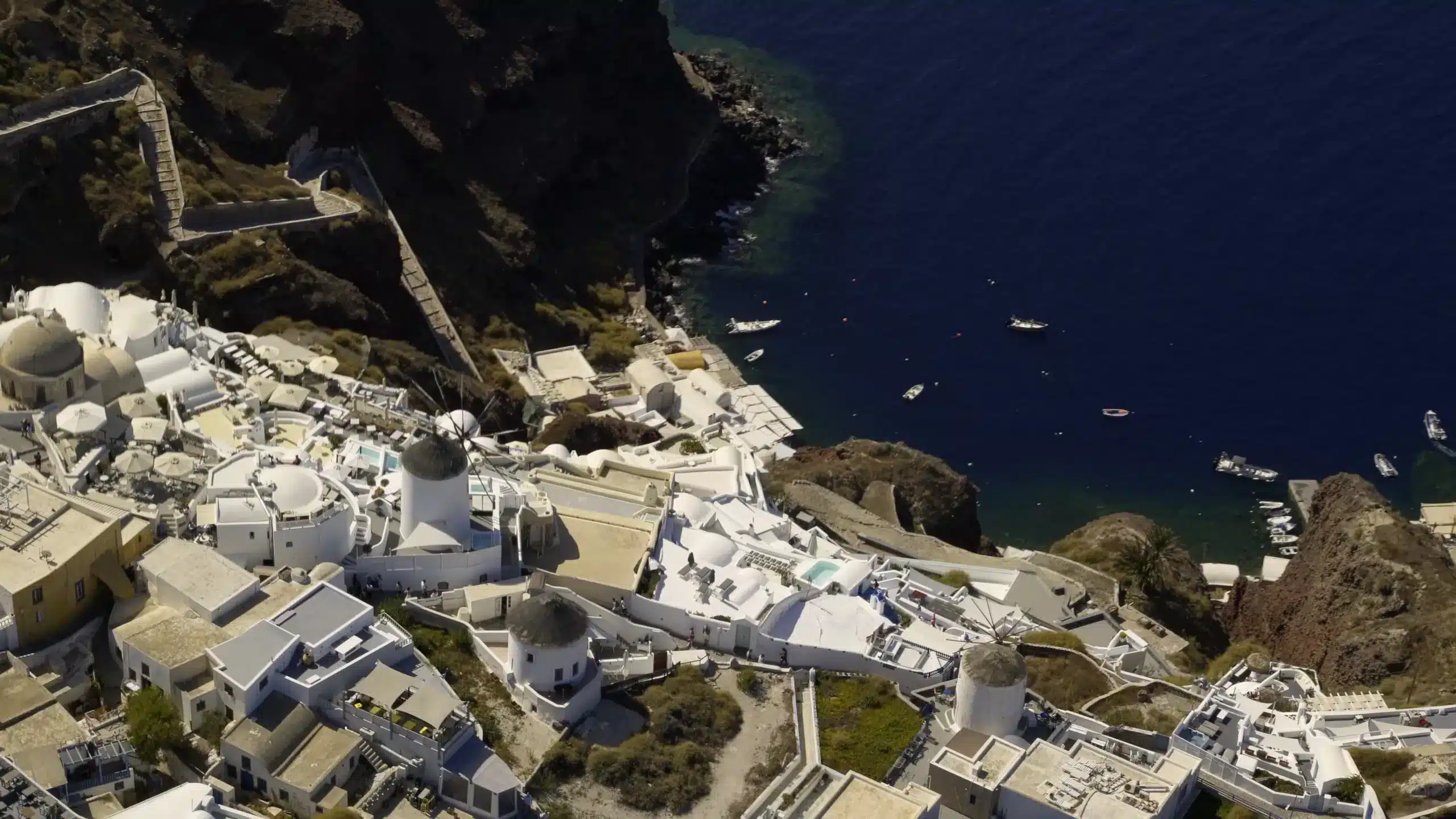 Aerial view of Oia's white houses on the Santorini caldera cliffs, seen from a helicopter